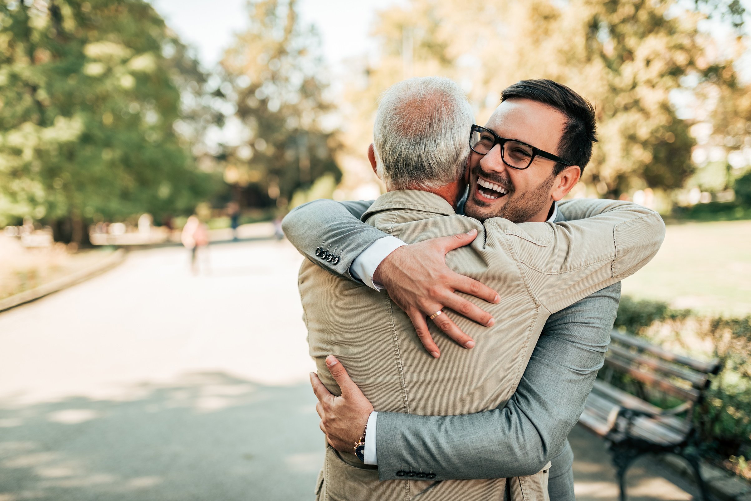 Family reunion. Father and son hugging outdoors.